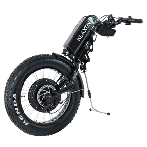 Front view of the Klaxon Klick Monster wheelchair power add-on, featuring a large 20-inch fat tire for extreme off-road performance, integrated disc brakes, and ergonomic handlebars, isolated on a white background.
