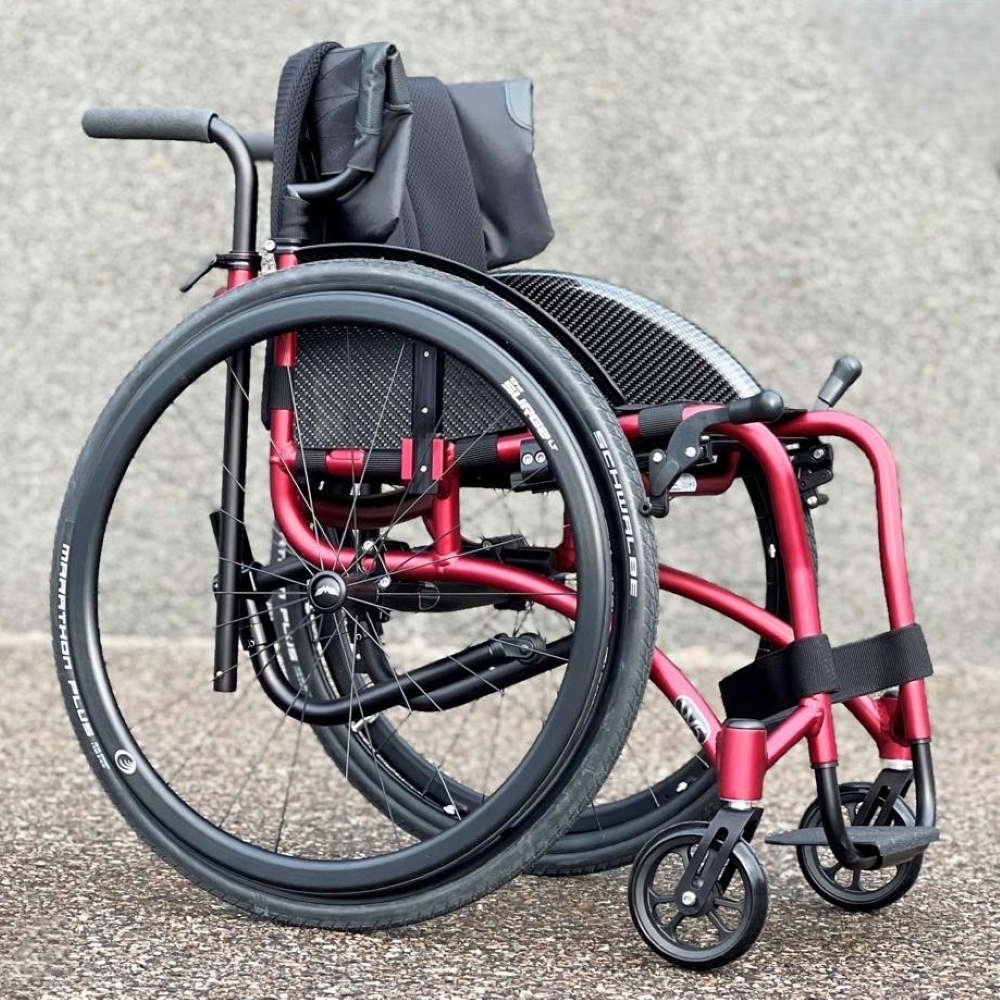 Red Wolturnus W5 SL Wheelchair against a pebble background