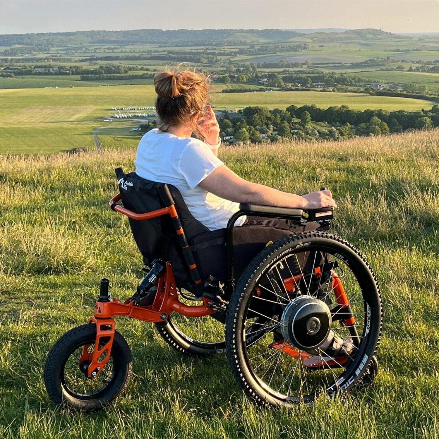 Woman in an SDMotion Trike All-terrain Powerchair outdoors in long grass