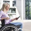 woman outside using phone in wheelchair