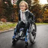 child outside on road riding in blue wheelchair